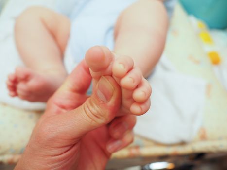 Baby receiving foot massage after diaper change with a thumb