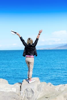 The back of an attractive young woman looking at the ocean view