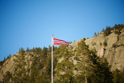 Norwegian pennant on a pole with mountains background