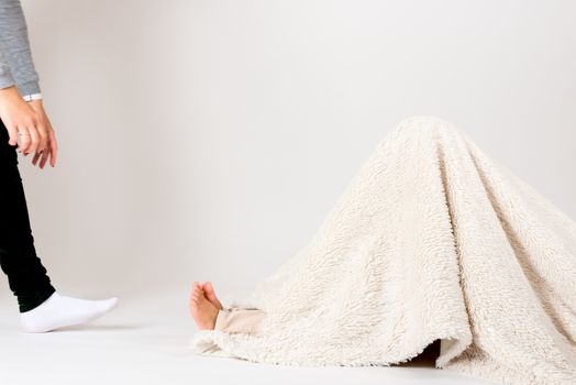 Boy model hiding under cover in photo studio