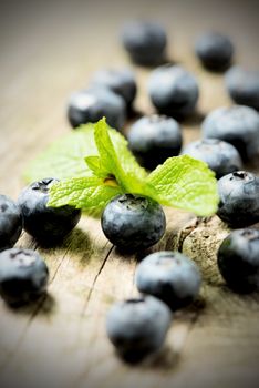 Fresh blueberries with mint leaves on a wooden background