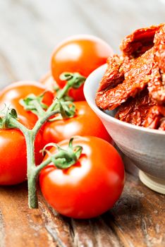 Fresh and dried tomatoes on old wooden table