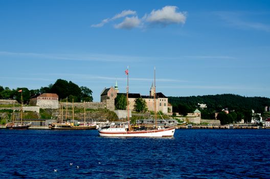 Old ship sailing in the Oslo fjord with Akershus fortress on background