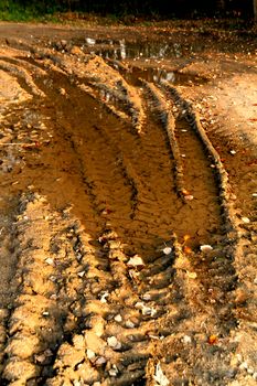 Dirty broken rural road with deep tire tracks