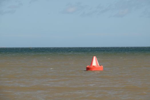 A red and white, Bedford buoy, safe water, inlet day marker on the sea.