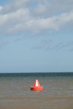 A red and white, Bedford buoy, safe water, inlet day marker on the sea.