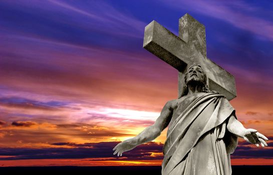 marble Holy cross with crucified Jesus Christ against dramatic sunset