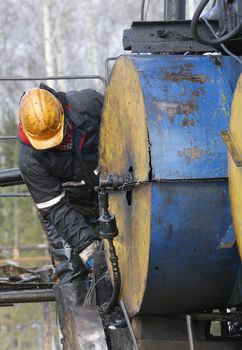 People at work. Worker works on an oil refinery.