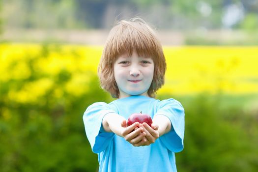 Boy Holding Red Apple in the Garden Smiling