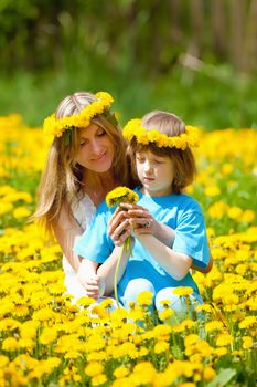Boy and his Mother Sitting in a Dandelion Field