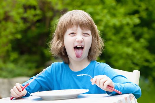 Blond Boy Eating Sticking out his Tongue