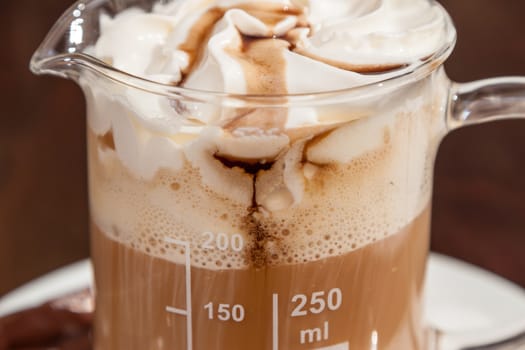 coffee in beaker with whipped cream and caramel topping