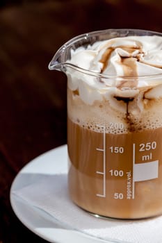 coffee in beaker with whipped cream and caramel topping