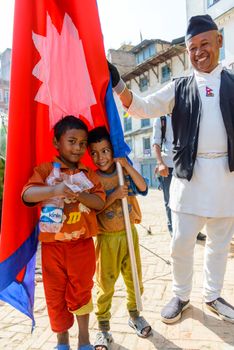 KATHMANDU, NEPAL - MAY 14, 2015: Two children poses with a Nepal flag.