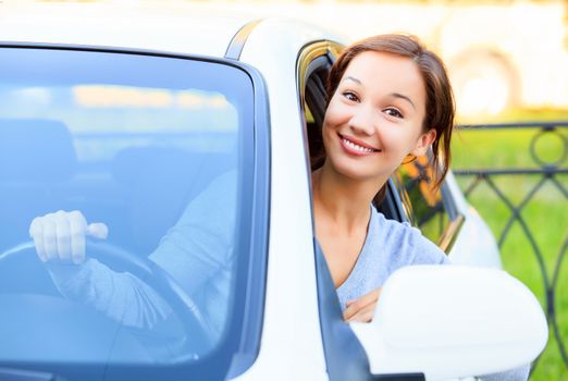 Pretty girl in a car smiling to you