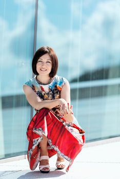 Brunette girl model in dress posing on exterior set