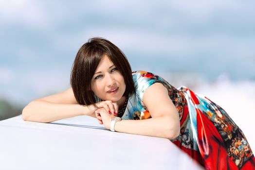 Brunette girl model in dress posing on exterior set