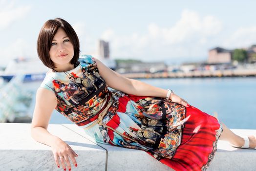 Brunette girl model in dress posing on exterior set