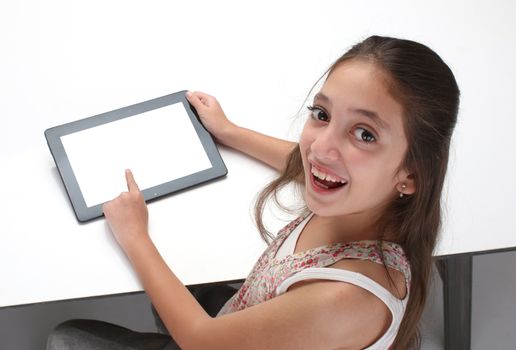 Beaitiful pre-teen girl using a tablet computer. High angle. Clipping path for the screen