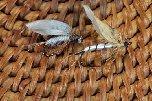 Macro photo of an artificial fly for fly fishing on a basketwork background.