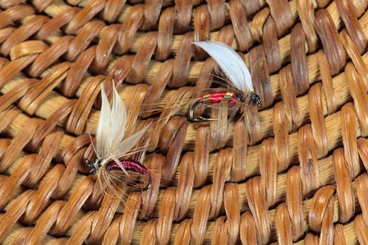 Macro photo of an artificial fly for fly fishing on a basketwork background.