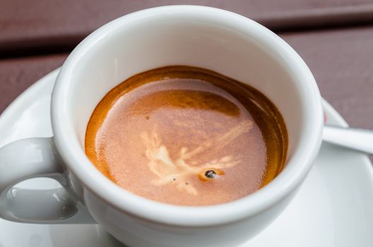 A cup of cappuccino in a white cup on a white saucer against white background.