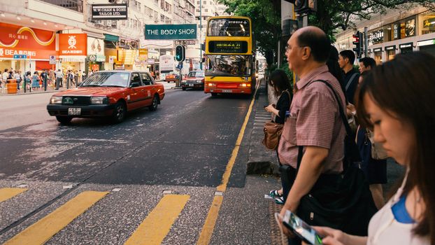 People waiting for the bus at bus stop in Hongkong street