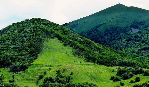 Beauty Green Hills Over Meadows at Sunny Day on Cloudy Sky background Outdoors