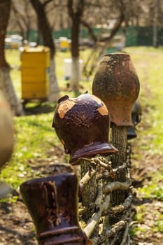 Old traditional clay jug hanging on the wooden fence