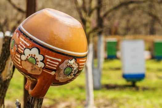 Old traditional clay jug hanging on the wooden fence