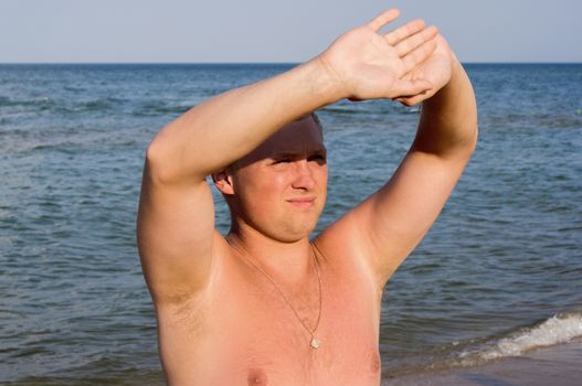 Nice guy squinting in the sun on beach. For your commercial and editorial use.