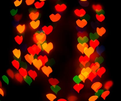 Defocused background lights or bokeh in the form of heart.