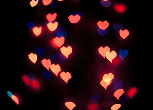 Defocused background lights or bokeh in the form of heart.