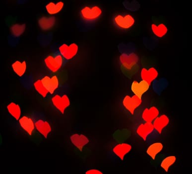 Defocused background lights or bokeh in the form of heart.