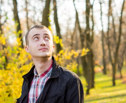 young attractive man in a black jacket in autumn park. For your commercial and editorial use.