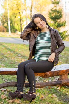 beautiful and sexy girl sitting on bench outdoors. 