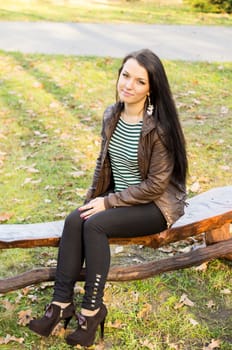 beautiful and sexy girl sitting on bench outdoors. 