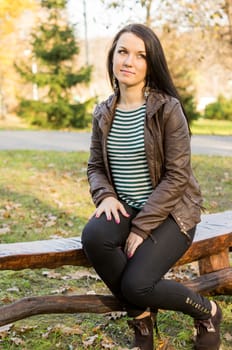 beautiful and sexy girl sitting on bench outdoors. 