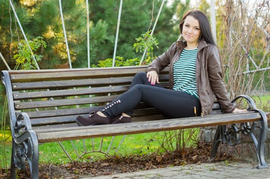 beautiful and sexy girl sitting on bench outdoors. 