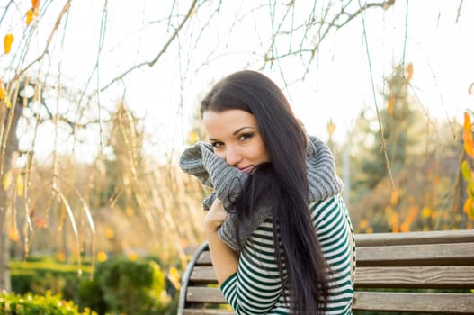 beautiful and sexy girl sitting on bench outdoors. 