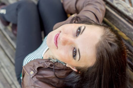 beautiful and sexy girl sitting on bench outdoors. 