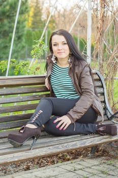 beautiful and sexy girl sitting on bench outdoors. 