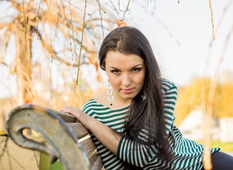 beautiful and sexy girl sitting on bench outdoors. 