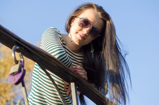 beautiful and sexy girl sitting on bench outdoors. 