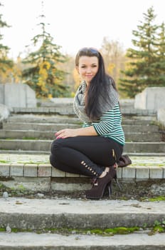 beautiful and sexy girl sitting on bench outdoors. 