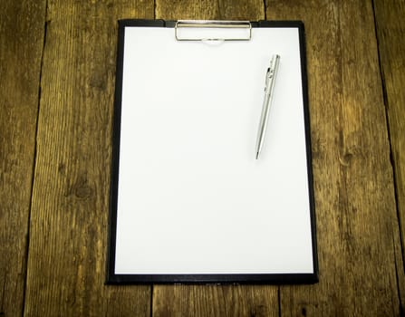 White paper and pen on wood background. For your commercial and editorial use