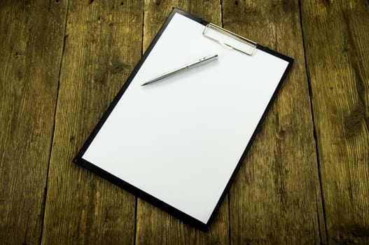 White paper and pen on wood background. For your commercial and editorial use