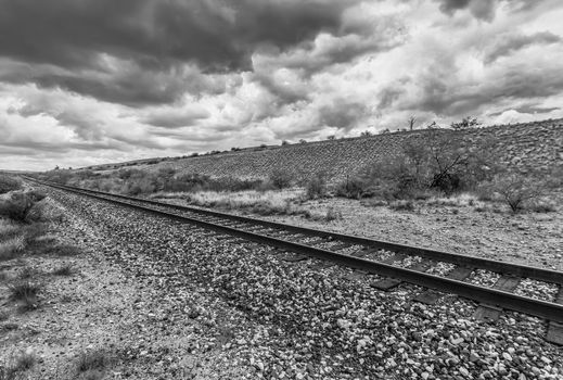 Empty railroad tracks with monsoon clouds in black and white