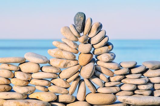 Arch of pebbles between of the stones on the seashore