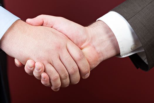 Business negotiations illustrated with a close up of a handshake between two men.